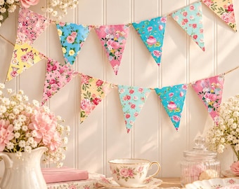 May include: A decorative bunting banner featuring triangular flags with various floral patterns in shades of pink, yellow, and blue, suspended on a string. The flags display roses, small blossoms, and butterflies against colorful backgrounds.