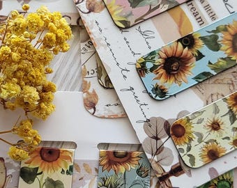 May include: A set of eight colorful bookmarks featuring a sunflower design. The bookmarks are made of a sturdy material and have a glossy finish. The bookmarks are perfect for adding a touch of whimsy to your reading experience.