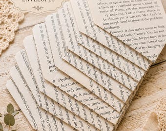 May include: A set of 10 envelopes crafted from vintage book pages, arranged in a fan shape. Each envelope features printed text from the original book pages. The text on the top envelope begins with the letter W and discusses mental states.