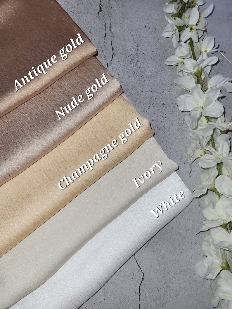 May include: Five swatches of fabric in different shades of beige and white. The swatches are labeled from top to bottom: Antique Gold, Nude Gold, Champagne Gold, Ivory, and White.