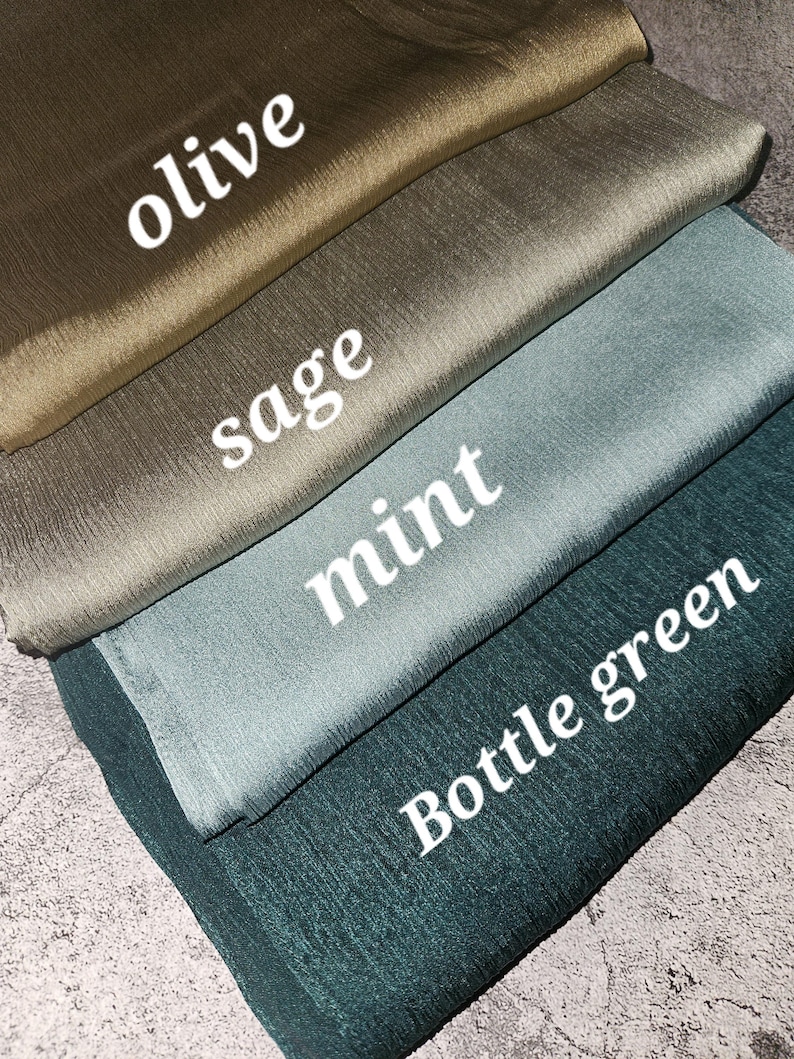May include: Four fabric swatches in different shades of green: olive, sage, mint, and bottle green. The swatches are folded and stacked on top of each other.