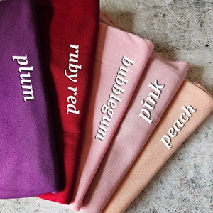 K&ouml;nnte beinhalten: F&uuml;nf Stoffmuster in verschiedenen Schattierungen von Rosa, Rot und Lila. Die Muster sind mit "Pflaume", "Rubinrot", "Kaugummi", "Rosa" und "Pfirsich" beschriftet.