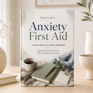Può includere: Un libro intitolato "Anxiety First Aid" con il testo "Quiet Guides" e "75-PAGE PRACTICAL GUIDE & WORKBOOK". Il libro è su una superficie di legno con una tazza di tè, un diario e una penna.