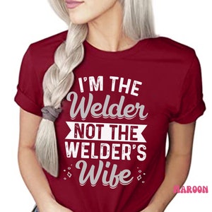 K&ouml;nnte beinhalten: Rotes T-Shirt mit kurzen &Auml;rmeln und wei&szlig;em Text, der "Ich bin der Schwei&szlig;er, nicht die Frau des Schweissers" lautet.