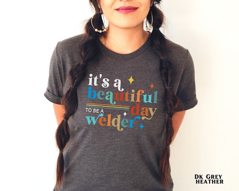 May include: Dark grey heather t-shirt with the text "it's a beautiful day to be a welder" in colorful letters with stars and stripes.