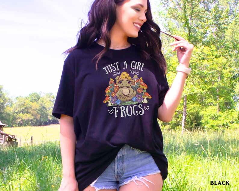 May include: Black t-shirt with a graphic of a frog surrounded by mushrooms and the text "Just a girl who loves frogs".