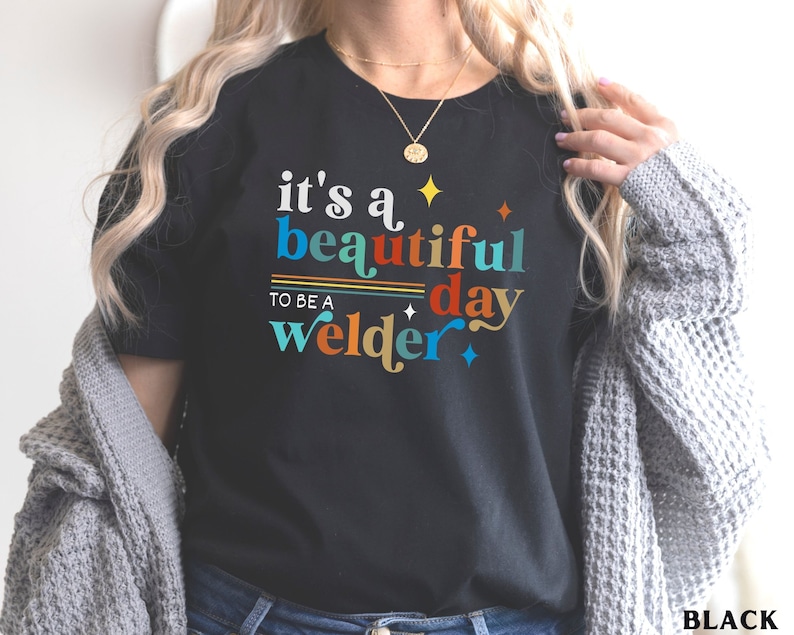 May include: Black t-shirt with the text "it's a beautiful day to be a welder" in colorful letters.