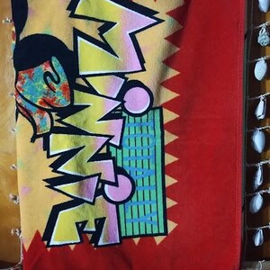 May include: A red beach towel with a yellow, pink, and blue graphic of Mickey Mouse and the word "SUMMER" in a stylized font.