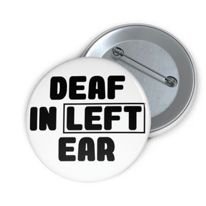May include: White button with black text that reads "DEAF IN LEFT EAR".