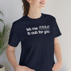 May include: A navy blue t-shirt with white text that reads "let me it out for you" and includes a graphic of hands signing the phrase in American Sign Language.