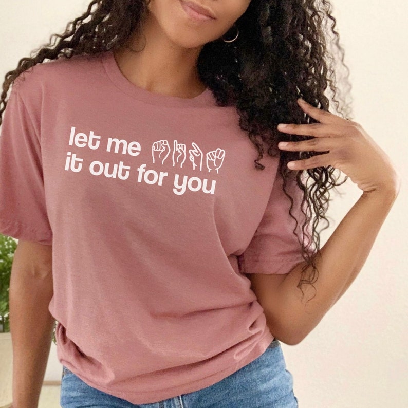 May include: A pink t-shirt with the text "let me it out for you" in white. The text is accompanied by a row of hand gestures in sign language.