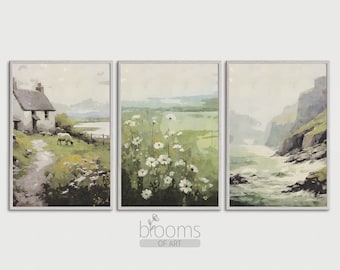 May include: A set of three framed watercolour paintings depicting a cottage with a sheep, a field of white flowers, and a rocky coastline with crashing waves. The paintings are in a muted colour palette of greens, blues, and greys.