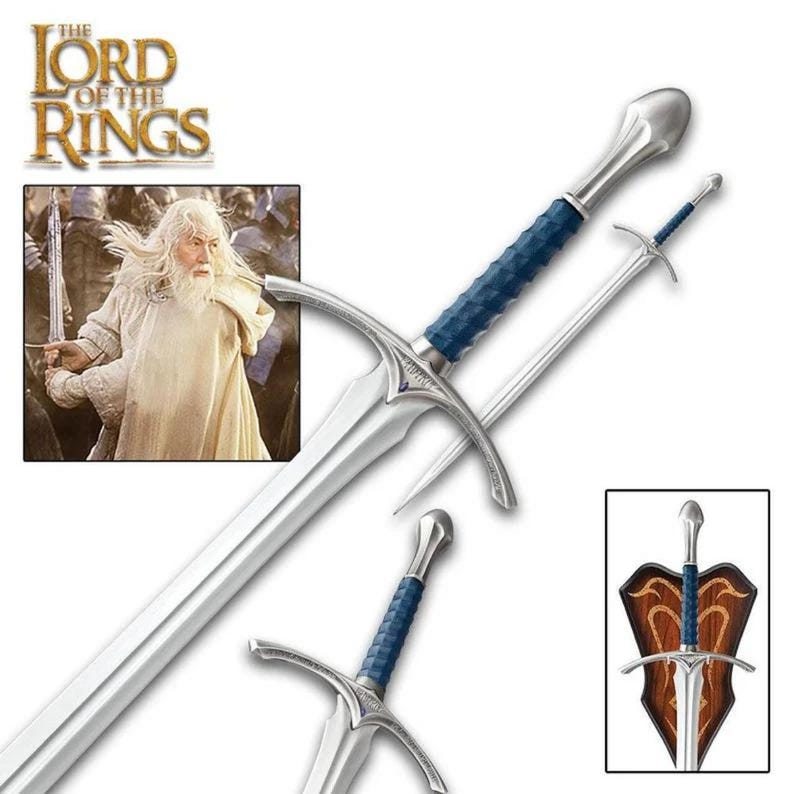 May include: A silver sword with a blue handle and a silver blade. The sword is displayed on a wooden plaque with the words "The Lord of the Rings" on it.