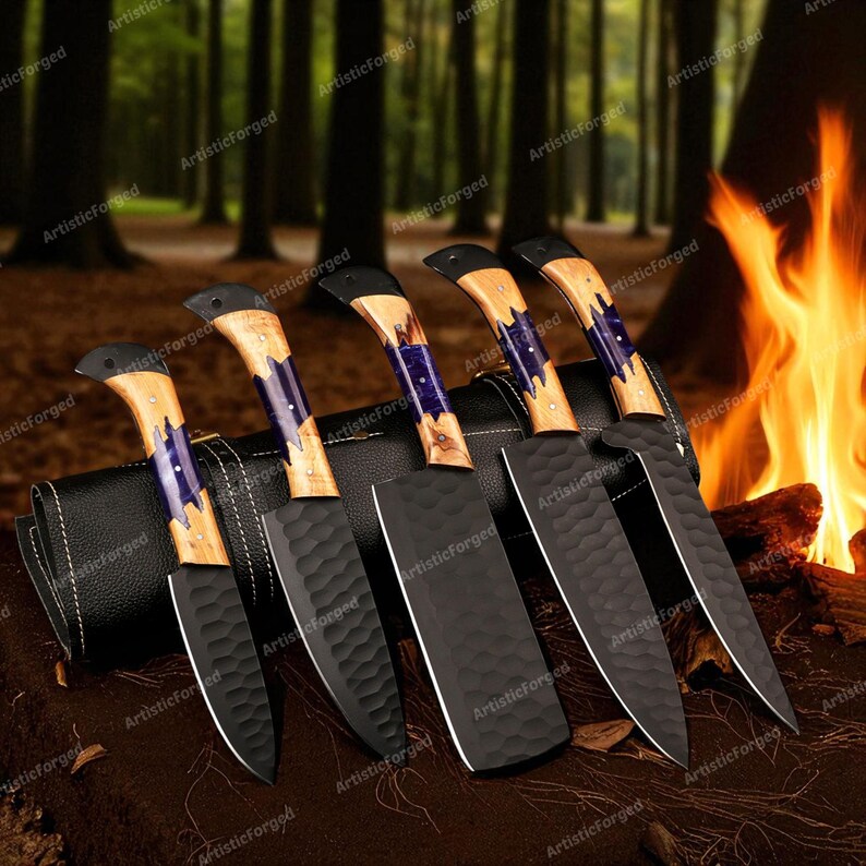 May include: A set of six handcrafted kitchen knives with black blades and wooden handles. The handles feature a light wood grain with blue and purple accents. The knives are displayed on a dark surface with a forest background and a campfire.