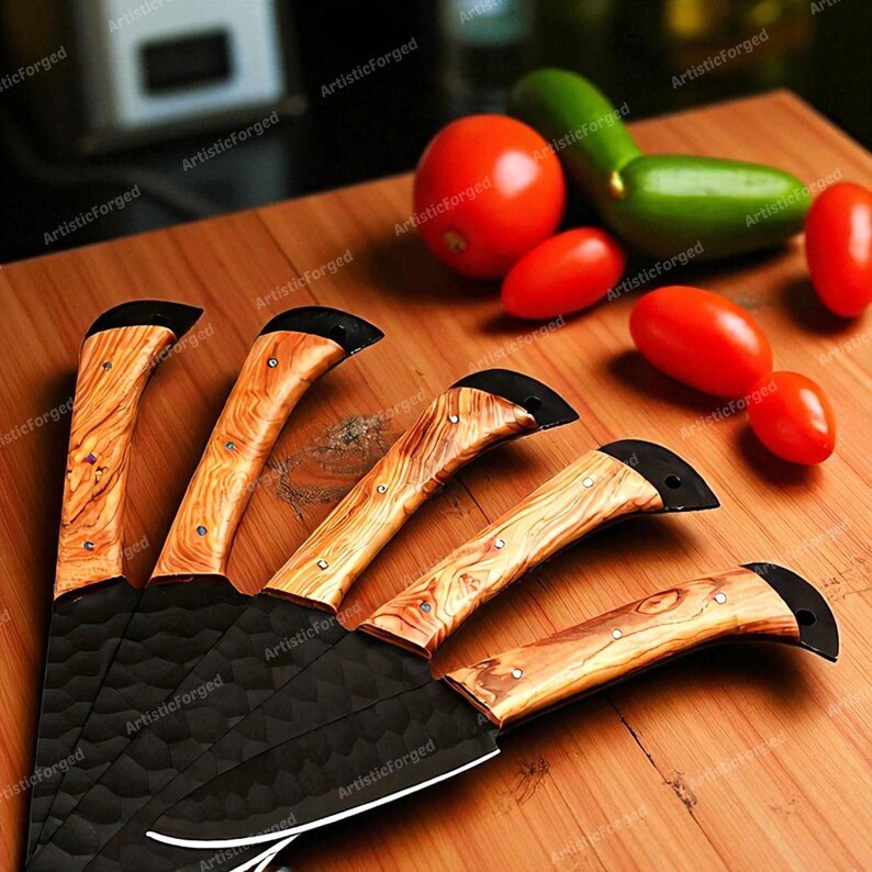 May include: A set of five kitchen knives with textured black blades and wooden handles. The handles have a light brown wood grain pattern and are accented with small silver rivets. Red and green vegetables are arranged on a wooden surface.