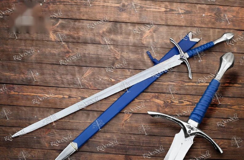 May include: Two silver swords with blue scabbards and handles. The swords have a pointed tip and a curved guard. The swords are lying on a wooden surface.