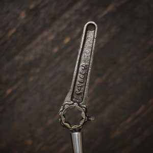 May include: A silver wrench with a black handle and a star-shaped opening. The handle is marked with the text "W-V880-A".