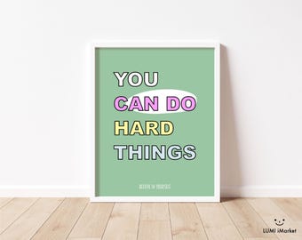 May include: A framed print with the words "YOU CAN DO HARD THINGS" in a colorful, bold font on a light green background. The text is outlined in black, with "CAN DO" in a pink oval. The phrase "BELIEVE IN YOURSELF" is at the bottom.