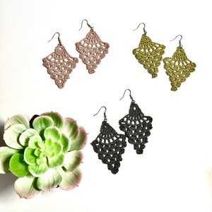 May include: Three pairs of crocheted earrings in pink, gold, and black. Each pair features a delicate, lacy design.