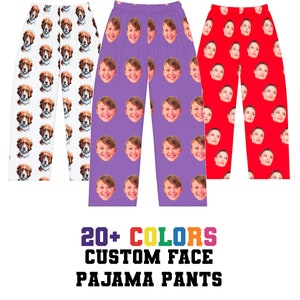 May include: Three pairs of pajama pants with different face patterns. The pants are white, purple, and red. The text on the bottom of the image reads "20+ COLORS CUSTOM FACE PAJAMA PANTS".