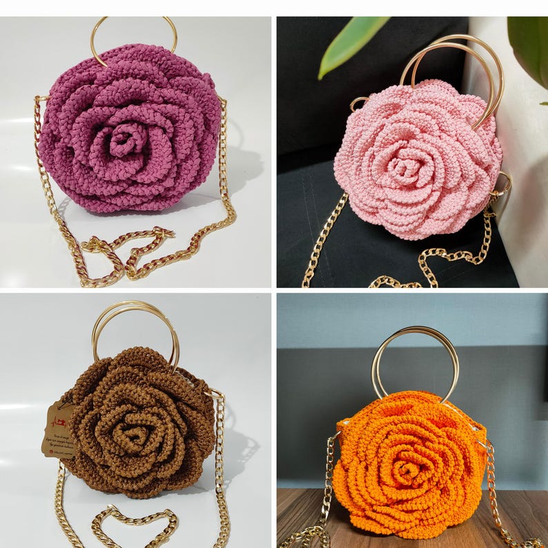 May include: A collection of four round crochet bags shaped like blooming roses, each featuring a gold-tone metal circular handle and a matching gold-tone chain shoulder strap. The bags are available in deep magenta, light pink, brown, and bright orange.