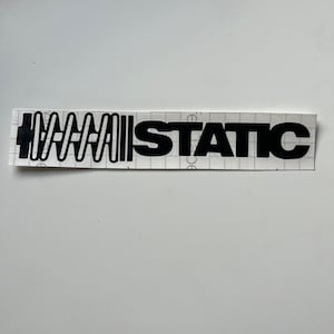 Könnte beinhalten: Schwarz-weißer Aufkleber mit dem Text "STATIC" und einem stilisierten Federdesign.