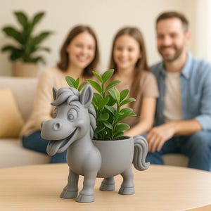 Könnte beinhalten: Ein grauer Pferde-Pflanztopf im Cartoon-Stil mit einem lächelnden Gesicht und einer grünen Pflanze im Inneren. Der Pflanztopf steht auf einem Holztisch. Der Hintergrund zeigt eine Familie, die auf einem Sofa sitzt.