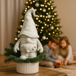 May include: A white ceramic gnome figure with a long, curved hat and beard, set in a white, ribbed planter with evergreen branches. A Christmas tree with lights is in the background.