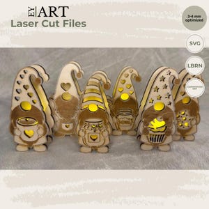 May include: A set of six laser-cut wooden gnome figures with light-colored wood grain. Each gnome features cut-out patterns like hearts and stars, with internal yellow lighting. One gnome holds a jar labeled HONIG. Text includes EY ART Laser Cut Files.
