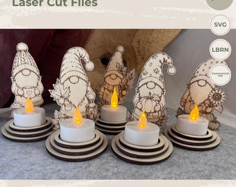 May include: Five laser-cut wooden gnome silhouettes with intricate engraved details, each standing on a tiered circular base with a battery-operated LED tea light. The text EY ART Laser Cut Files, 3-4 mm optimized, SVG, LBRN, and Commercial use is visible.