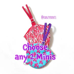 May include: Two small fabric items with straps, one red with a chili pepper pattern, the other blue with pink balloon dog graphics. Text reads "Choose any 2 Minis" in purple. The brand name "@FANZYPANTS" is also visible.