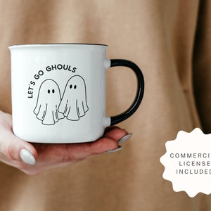 K&ouml;nnte beinhalten: Eine wei&szlig;e Keramiktasse mit schwarzem Henkel. Die Tasse hat einen schwarzen Umriss und den Text "Let's go ghouls" mit zwei Geisterillustrationen.