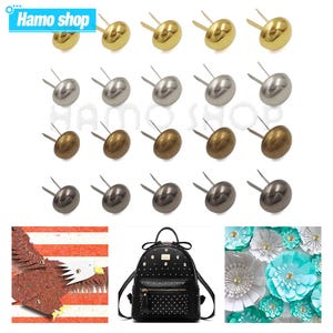 Puede incluir: Surtido de 18 clavos de metal dorado, plateado y bronce. Los clavos están dispuestos en tres filas de seis. Cada clavo tiene una cabeza redonda y un eje puntiagudo.