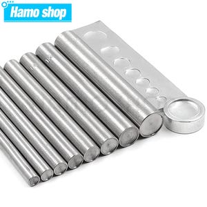 Puede incluir: Un juego de ocho herramientas de punzonado de metal plateado con punzones de diferentes tamaños. Las herramientas están dispuestas en orden de tamaño, con el punzón más grande a la izquierda y el más pequeño a la derecha. Las herramientas se utilizan para perforar agujeros en cuero, tela y otros materiales.