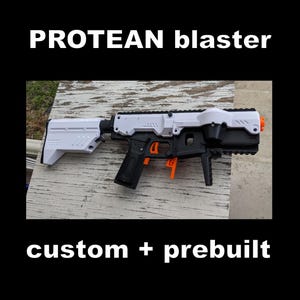May include: A PROTEAN blaster toy with a white and black frame, featuring bright orange trigger and lever components. The text PROTEAN blaster and custom + prebuilt is displayed in white against a black background surrounding the toy blaster.