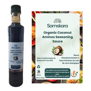 Pode incluir: Uma garrafa alta de vidro transparente com molho de tempero de aminos de coco orgânico Samskara. O rótulo apresenta um gráfico de coco, o nome da marca e texto indicando ser uma alternativa ao molho de soja com baixo sódio, 500ml / 650g.