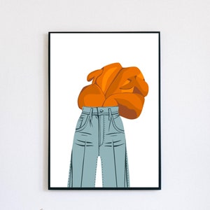 May include: A framed art print featuring a stylized illustration of a pair of light blue jeans and an orange top. The artwork is set against a white background, with a black frame. The print is a modern, minimalist design.