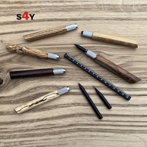 Peut inclure: Un ensemble de crayons mécaniques en bois et en métal avec une règle et deux crayons graphite noirs. Les crayons présentent une variété de motifs de grain de bois et d'accents métalliques.