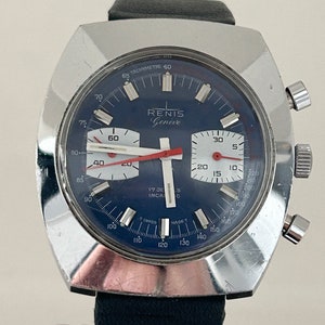 May include: A silver chronograph wristwatch with a blue face and red accents. The watch face has the text "RENIS Gen&egrave;ve" and "17 JE INCA C" printed on it. The watch has a black leather band.