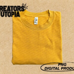 May include: A folded mustard yellow t-shirt with a blank front. The t-shirt is a digital product and is available as a PNG file.