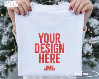 White T-Shirt Mockup Christmas Folded Shirt Held in Hands Winter Snowy Background Festive Holiday JPEG Mockup for Etsy Canva POD Sellers