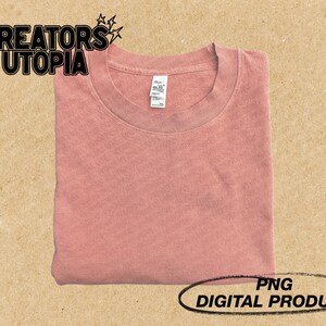 May include: A folded, pink t-shirt with a crew neck. The t-shirt is a digital product, available as a PNG file.