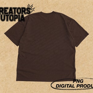 Op de afbeelding: Een bruin T-shirt met de tekst "CREATORS UTOPIA" gedrukt op de voorkant. De tekst is in zwart en wit met een stervormig ontwerp erboven. PNG DIGITAAL PRODUCT.