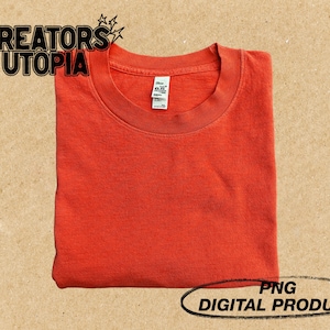 May include: A folded orange t-shirt with a blank front. The t-shirt is a digital product, not a physical item.