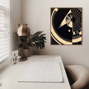 Puede incluir: Una impresi&oacute;n de arte abstracto geom&eacute;trico en blanco y negro con un marco de madera. La impresi&oacute;n est&aacute; colgada en una pared blanca sobre un escritorio blanco con una l&aacute;mpara, una planta y un cuaderno.