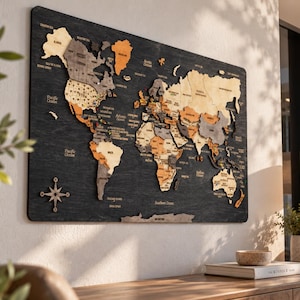 May include: A large rectangular wall-mounted world map made of layered wood pieces in shades of beige, tan, and dark gray. The continents are mounted on a dark charcoal wood background with engraved text for country names and oceans.