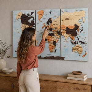 May include: A three-panel wooden world map wall art featuring continents in varying shades of brown and tan wood tones against a light blue background. The map displays country names and borders, with raised wooden pieces creating a layered effect.