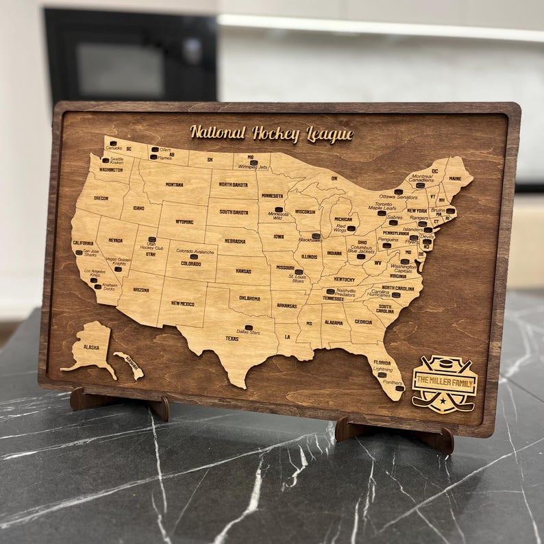 May include: A wooden map of the United States with the location of each National Hockey League team marked. The map is on a dark brown wooden base with the text "The Miller Family" and a hockey puck graphic.