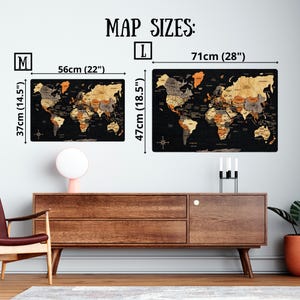 May include: Two rectangular world maps labeled M and L with black backgrounds and continents in shades of wood, orange, and gray. Size M is 56cm by 37cm (22 by 14.5 inches) and size L is 71cm by 47cm (28 by 18.5 inches). Text reads MAP SIZES.