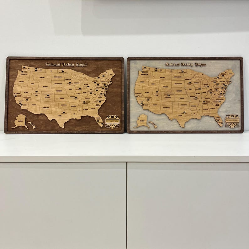 May include: Two wooden maps of the United States, one with a brown background and the other with a white background. Both maps show the locations of National Hockey League and American Hockey League teams. The maps are framed in dark wood.